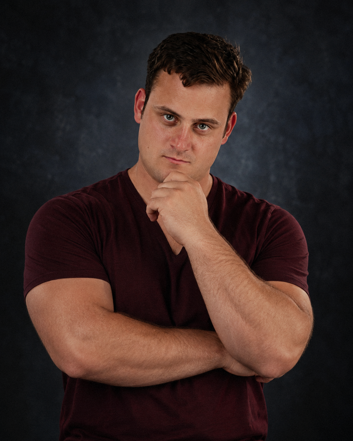 CARRER in a burgundy shirt against a dark background