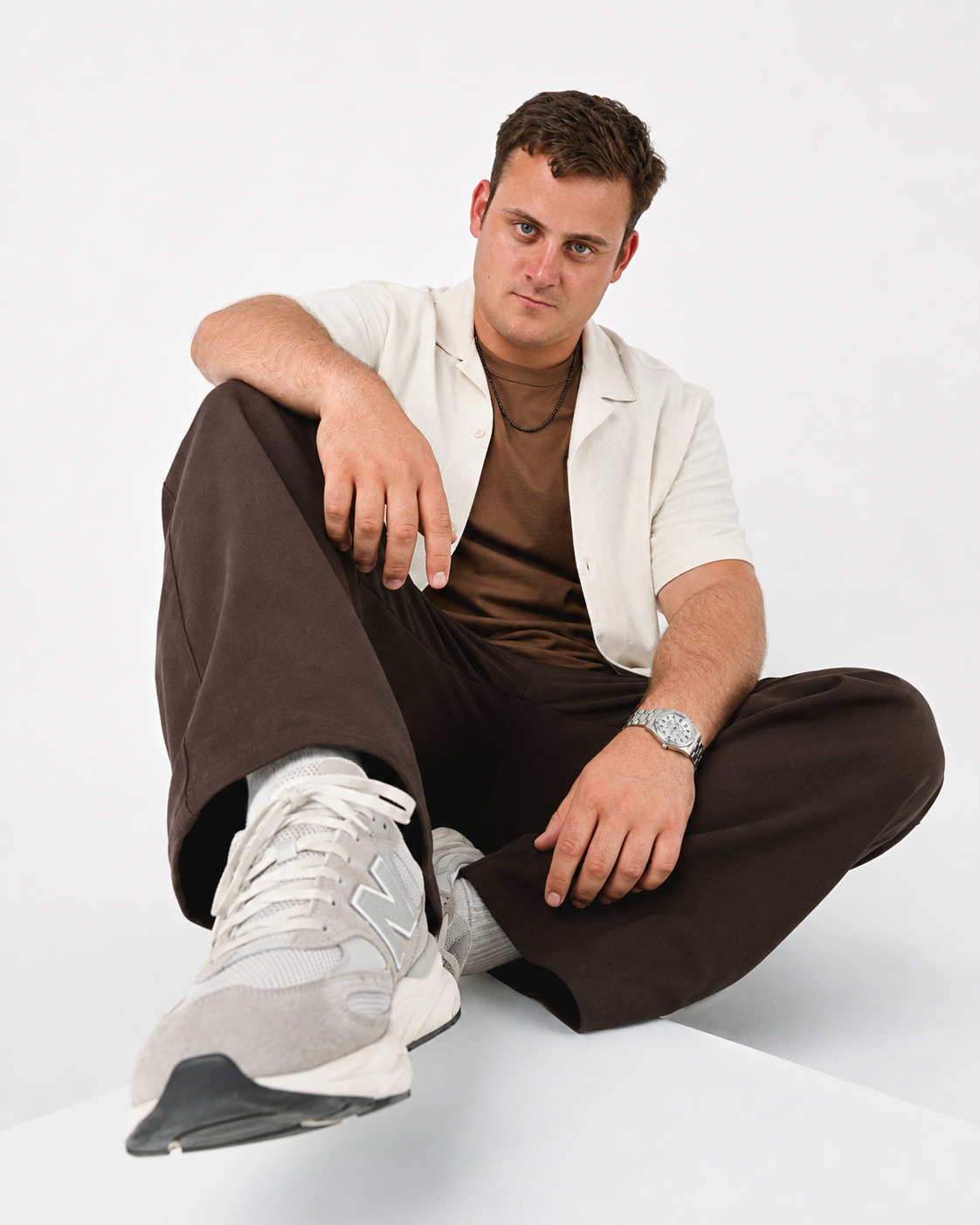 CARRER seated in a white shirt against a light background